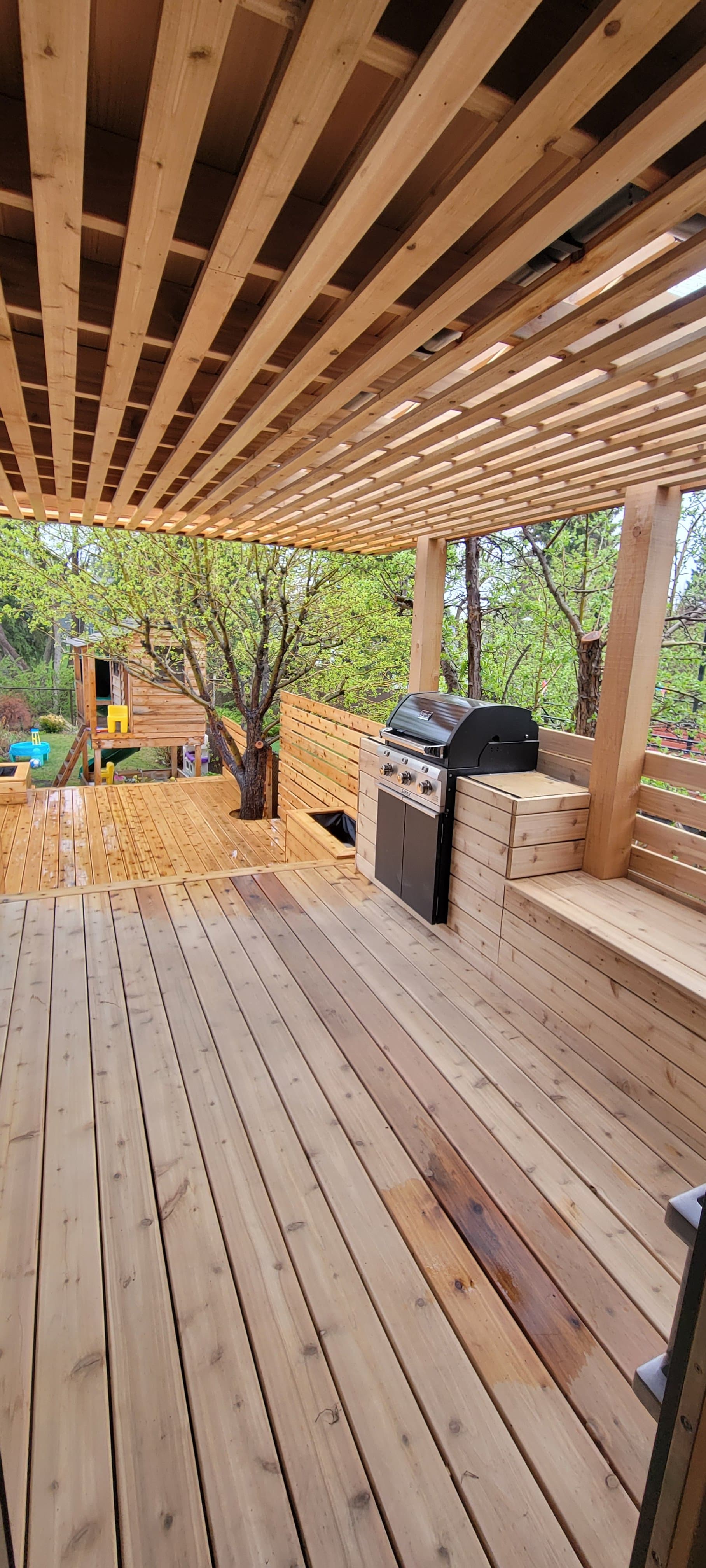 Cedar slat privacy screen with a built-in outdoor BBQ station under a pergola