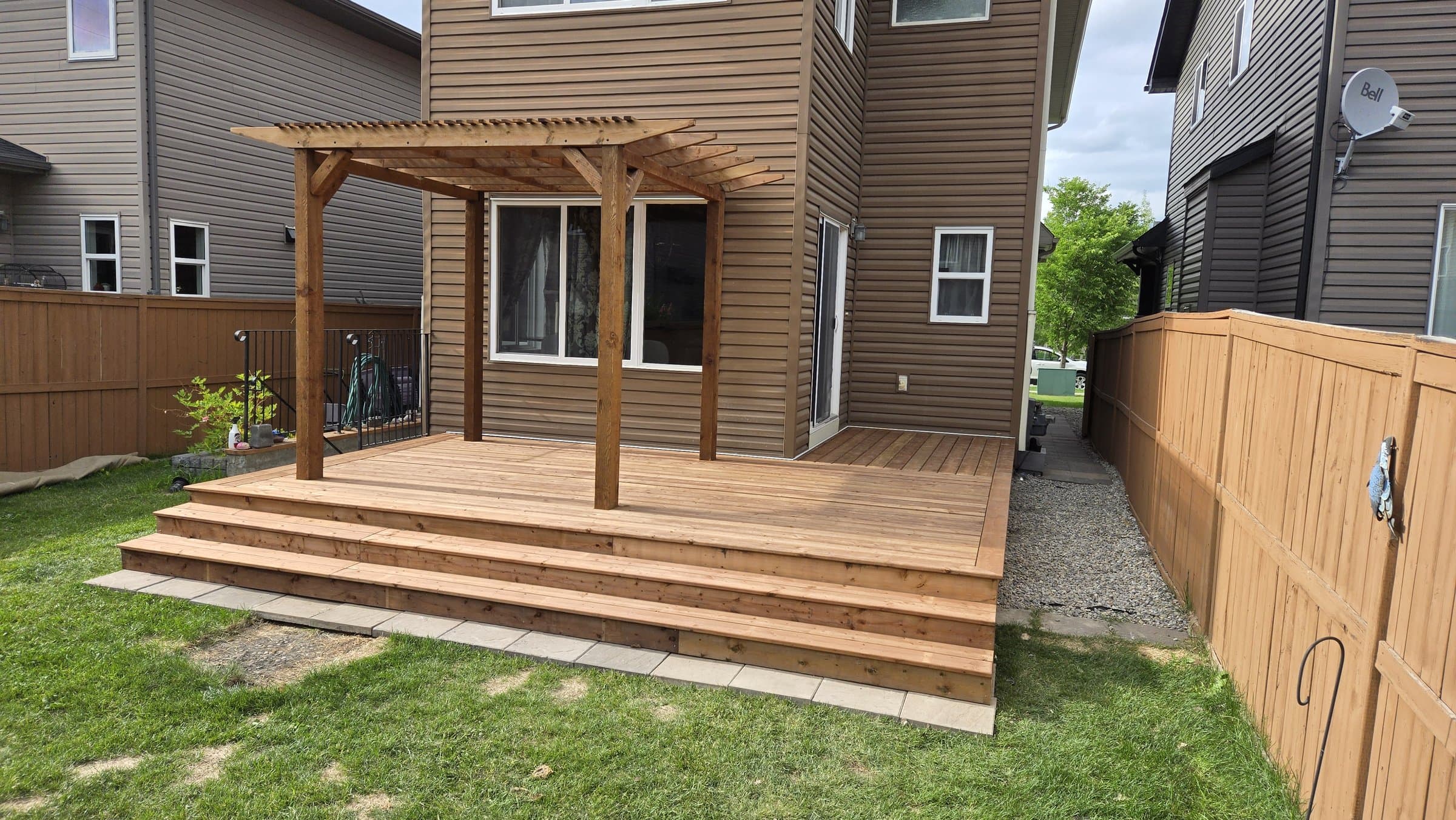Finished cedar deck and pergola attached to a two-story home