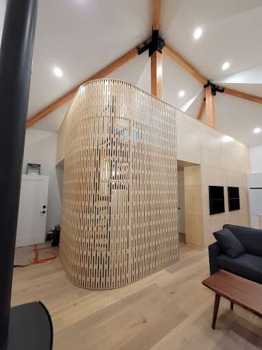 Curved custom wood slat feature wall in a vaulted-ceiling great room renovation